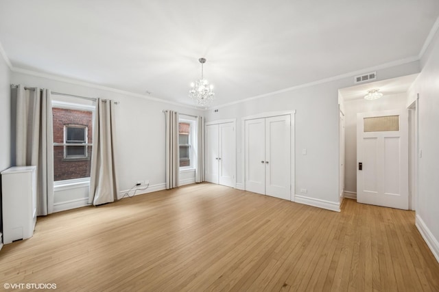 unfurnished bedroom with a notable chandelier, light hardwood / wood-style floors, and crown molding