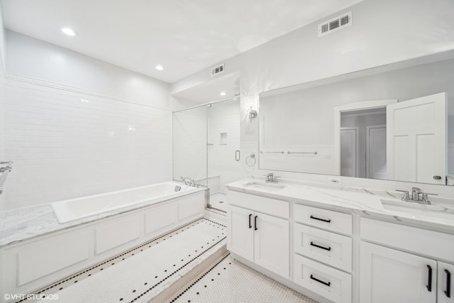 bathroom featuring vanity and independent shower and bath