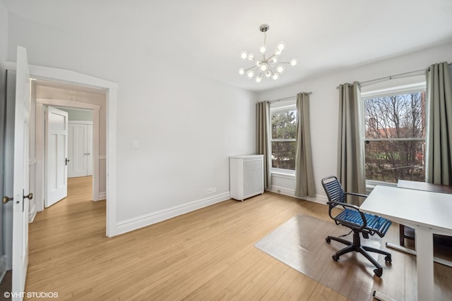 office area with light hardwood / wood-style flooring and an inviting chandelier