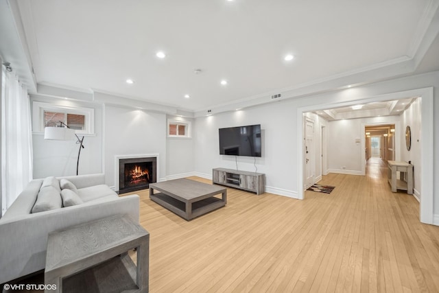 living room featuring crown molding and light wood-type flooring