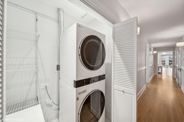 washroom featuring hardwood / wood-style floors and stacked washer and dryer