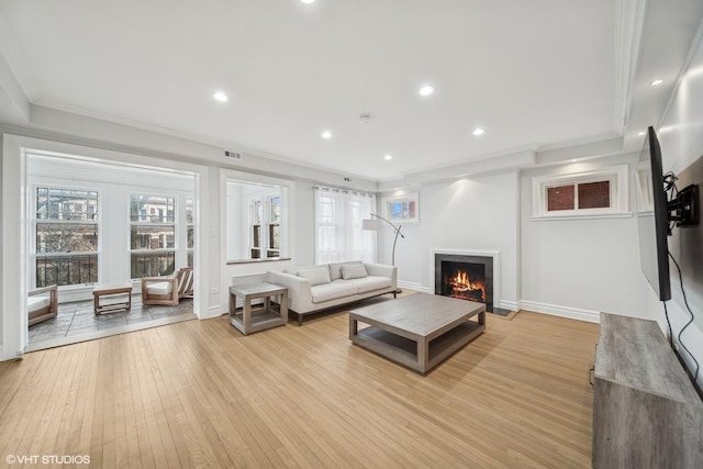 living room with light hardwood / wood-style flooring and ornamental molding