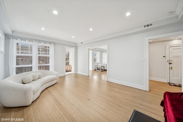 living room with light wood-type flooring and crown molding