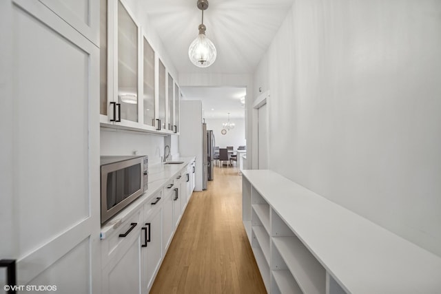 hall featuring light hardwood / wood-style flooring, a notable chandelier, and sink