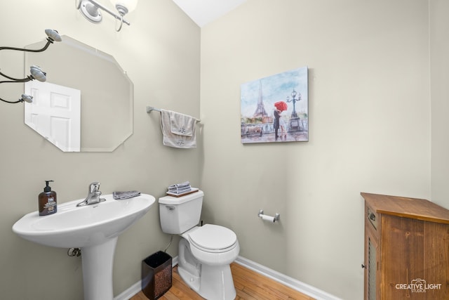 bathroom with hardwood / wood-style flooring and toilet