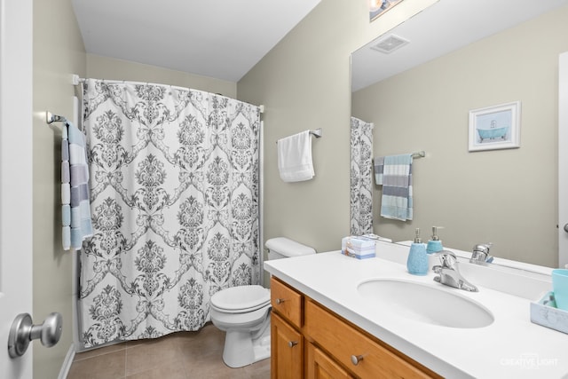 bathroom featuring tile patterned floors, toilet, vanity, and walk in shower