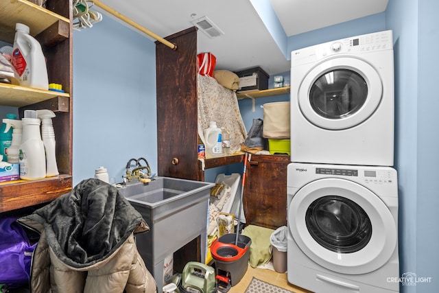 washroom with stacked washer and dryer and light tile patterned flooring