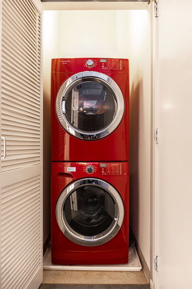 washroom featuring light tile patterned floors and stacked washer / drying machine