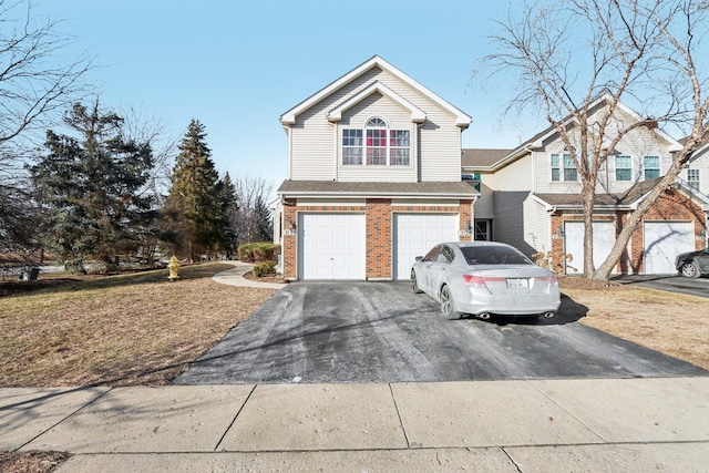 view of front of house with a garage, brick siding, and aphalt driveway