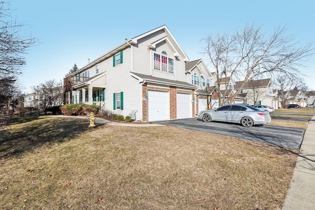 view of property exterior with a garage, driveway, a lawn, a residential view, and brick siding