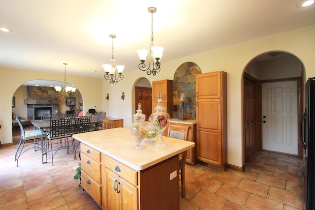 kitchen featuring a breakfast bar area, a kitchen island, pendant lighting, and a notable chandelier