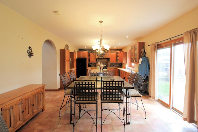 dining area featuring a notable chandelier, light tile patterned floors, and sink