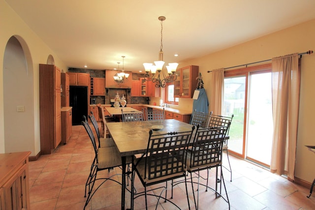 dining area featuring light tile patterned floors and an inviting chandelier