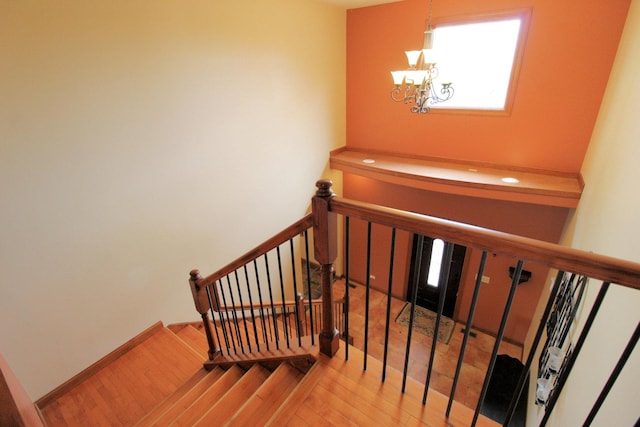 staircase featuring a chandelier and wood-type flooring