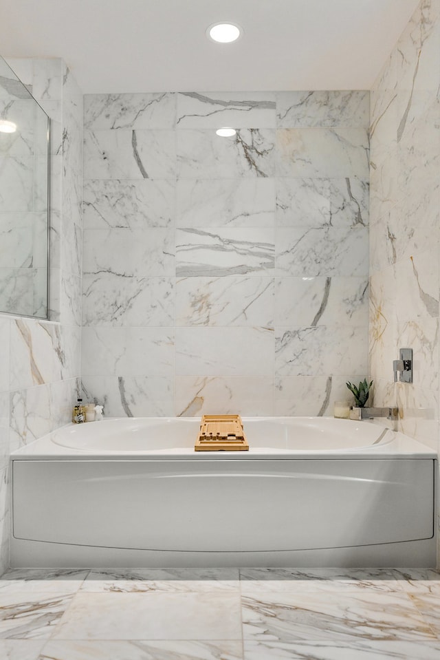 bathroom featuring tile walls and a tub