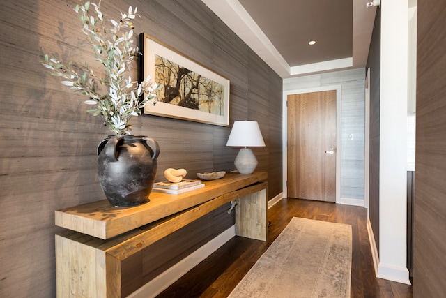 corridor featuring a raised ceiling and dark wood-type flooring