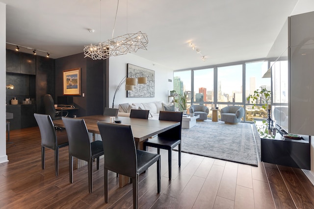 dining room with a chandelier and a wall of windows