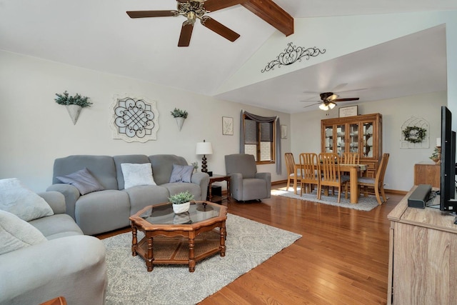 living room with vaulted ceiling with beams, hardwood / wood-style flooring, and ceiling fan