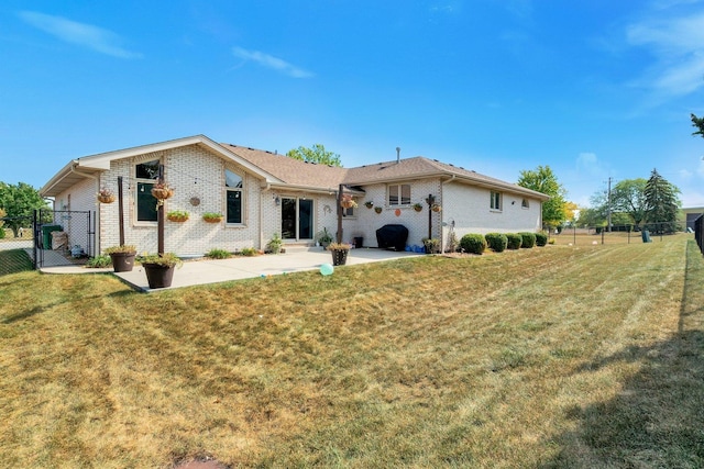 back of property with a patio area and a lawn