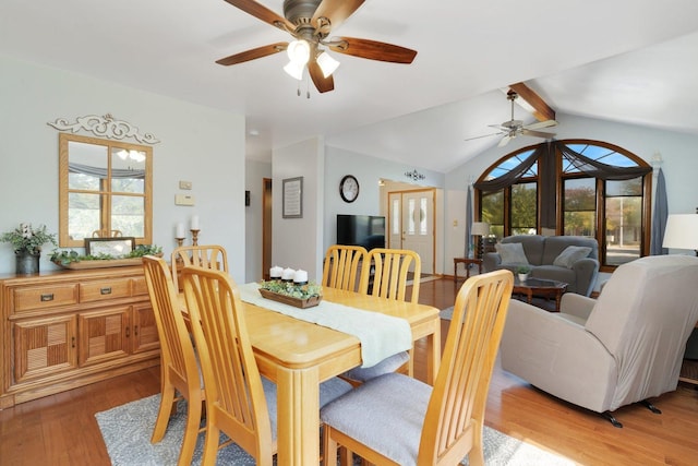 dining space with vaulted ceiling with beams, a healthy amount of sunlight, light wood-type flooring, and french doors