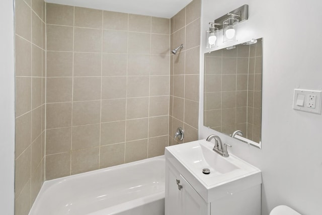 full bathroom with vanity, tiled shower / bath combo, and toilet