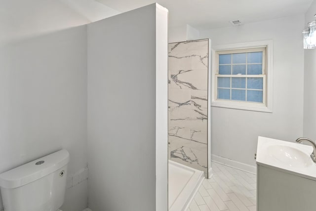 bathroom featuring walk in shower, vanity, and toilet