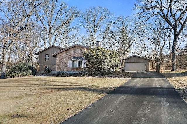 view of front facade with a garage, an outbuilding, and a front lawn