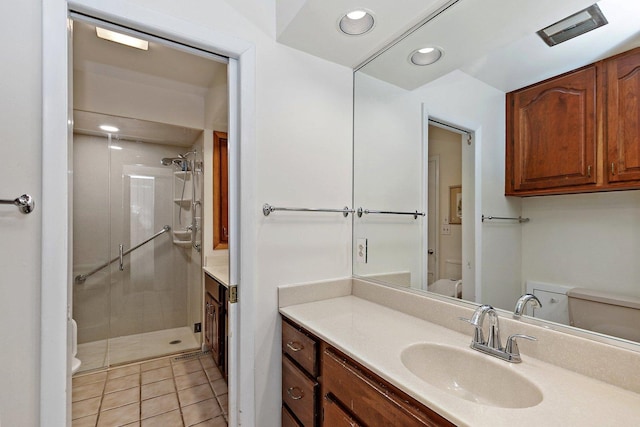 bathroom with vanity, toilet, tile patterned floors, and walk in shower