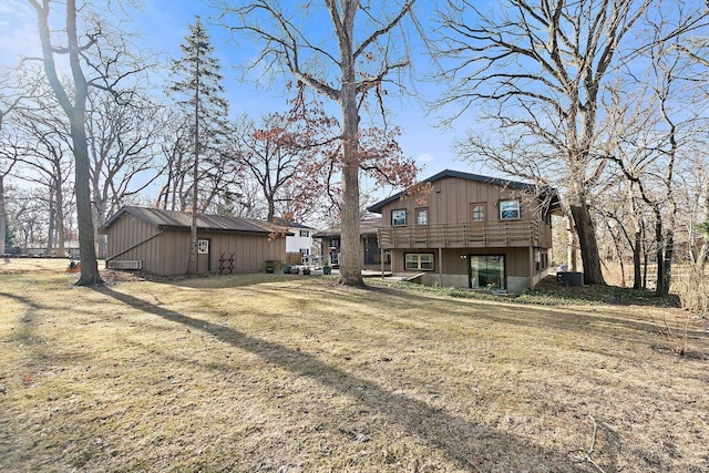 rear view of property featuring cooling unit and a yard