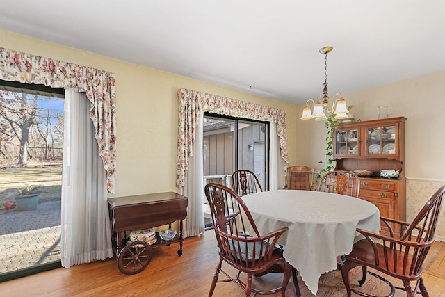 dining area featuring an inviting chandelier and light hardwood / wood-style floors