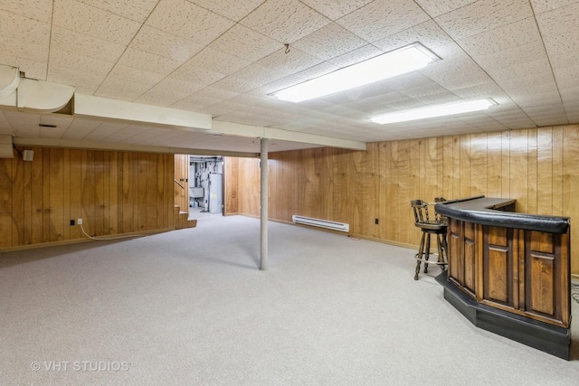 basement with carpet floors, wood walls, and indoor bar