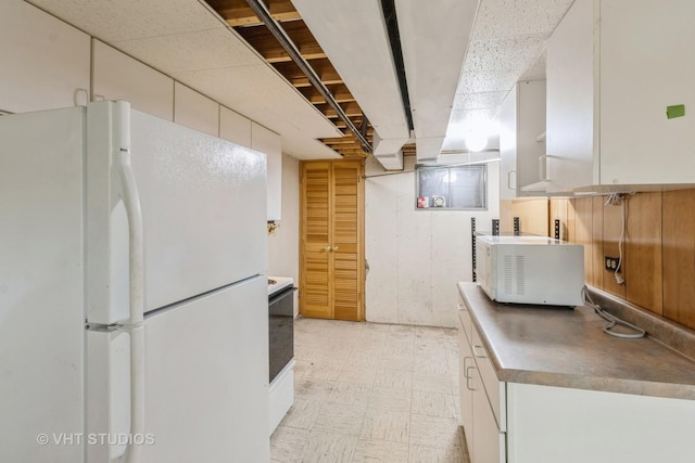 kitchen featuring white cabinetry and white fridge