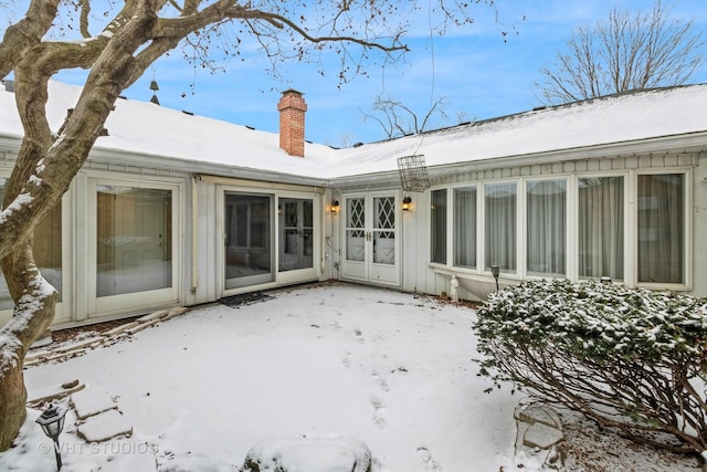 view of snow covered back of property