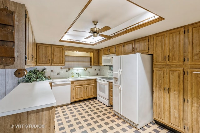 kitchen with sink, decorative backsplash, ceiling fan, kitchen peninsula, and white appliances