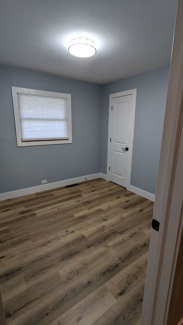 spare room with wood-type flooring