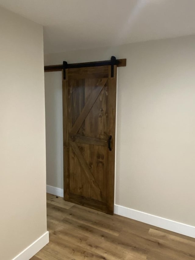 hall with hardwood / wood-style flooring and a barn door