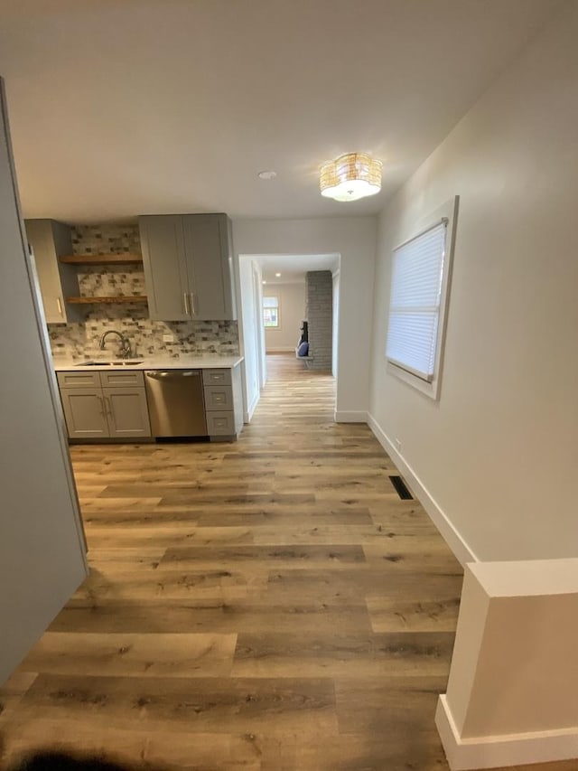 corridor with light hardwood / wood-style flooring and sink