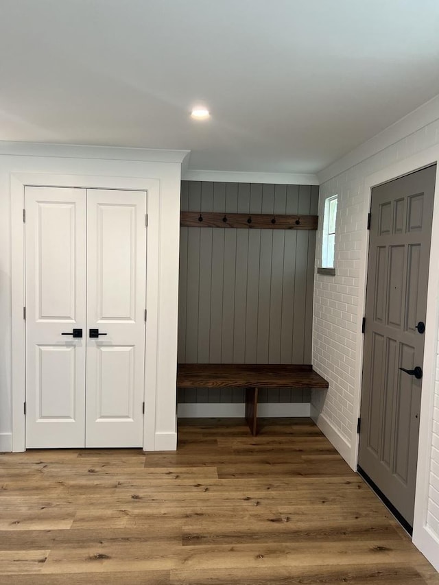 mudroom with light wood-type flooring and ornamental molding