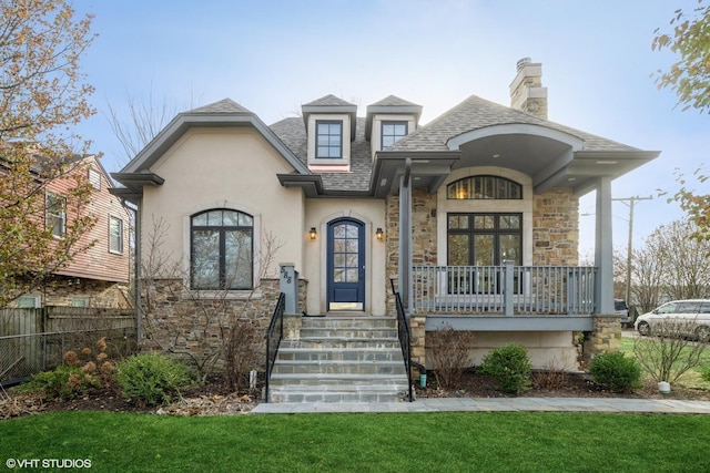 french country style house with a porch and a front lawn