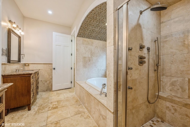 bathroom with vanity, separate shower and tub, and tile walls