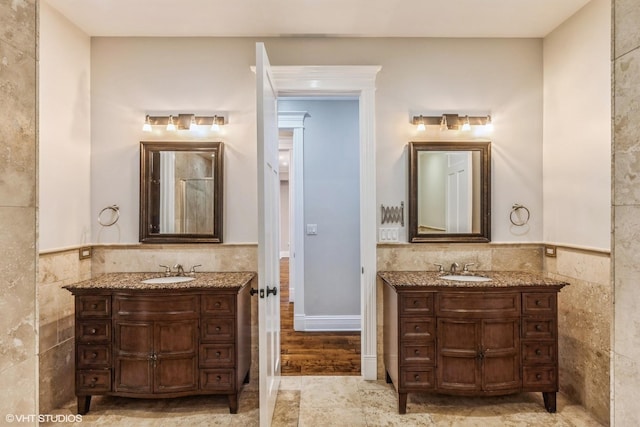 bathroom featuring vanity and tile walls