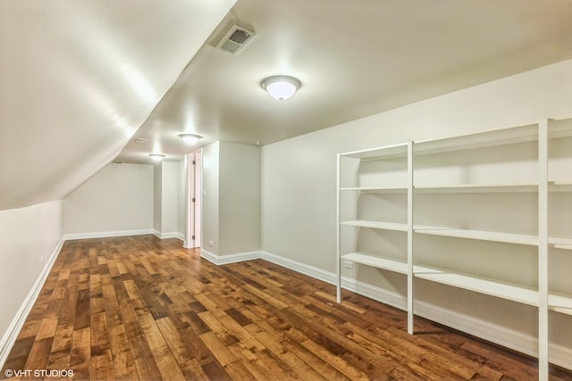 bonus room with dark hardwood / wood-style flooring and vaulted ceiling