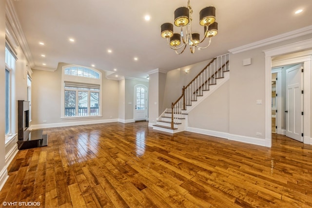 unfurnished living room featuring dark hardwood / wood-style flooring, an inviting chandelier, and crown molding