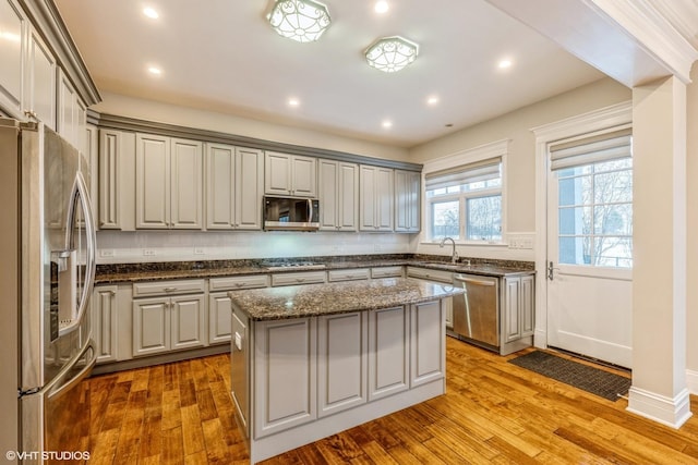 kitchen featuring gray cabinets, a center island, sink, and appliances with stainless steel finishes