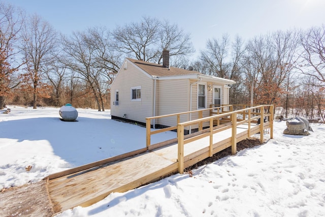 view of snow covered exterior featuring a wooden deck