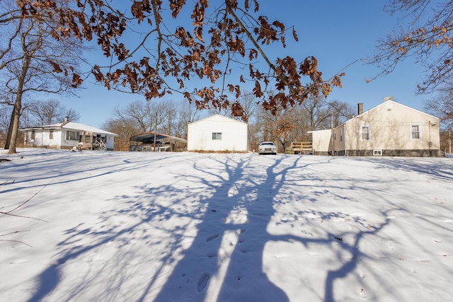 yard covered in snow with a carport