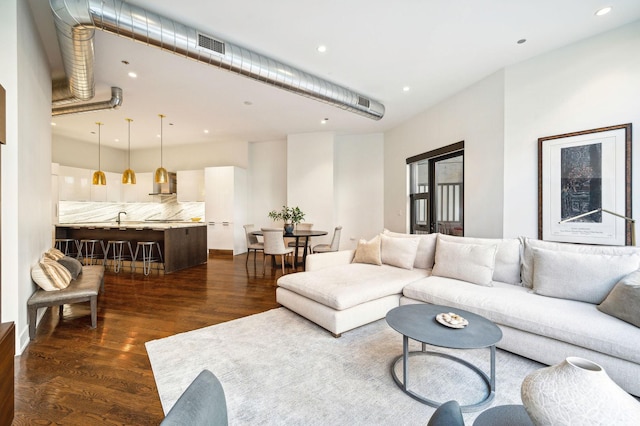 living room featuring dark wood-type flooring and sink