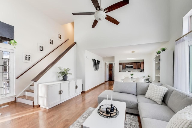 living room with light hardwood / wood-style flooring, plenty of natural light, and ceiling fan