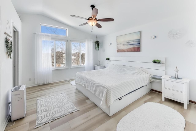 bedroom with ceiling fan, lofted ceiling, and light hardwood / wood-style flooring