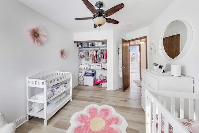 bedroom with ceiling fan, a closet, and light hardwood / wood-style flooring